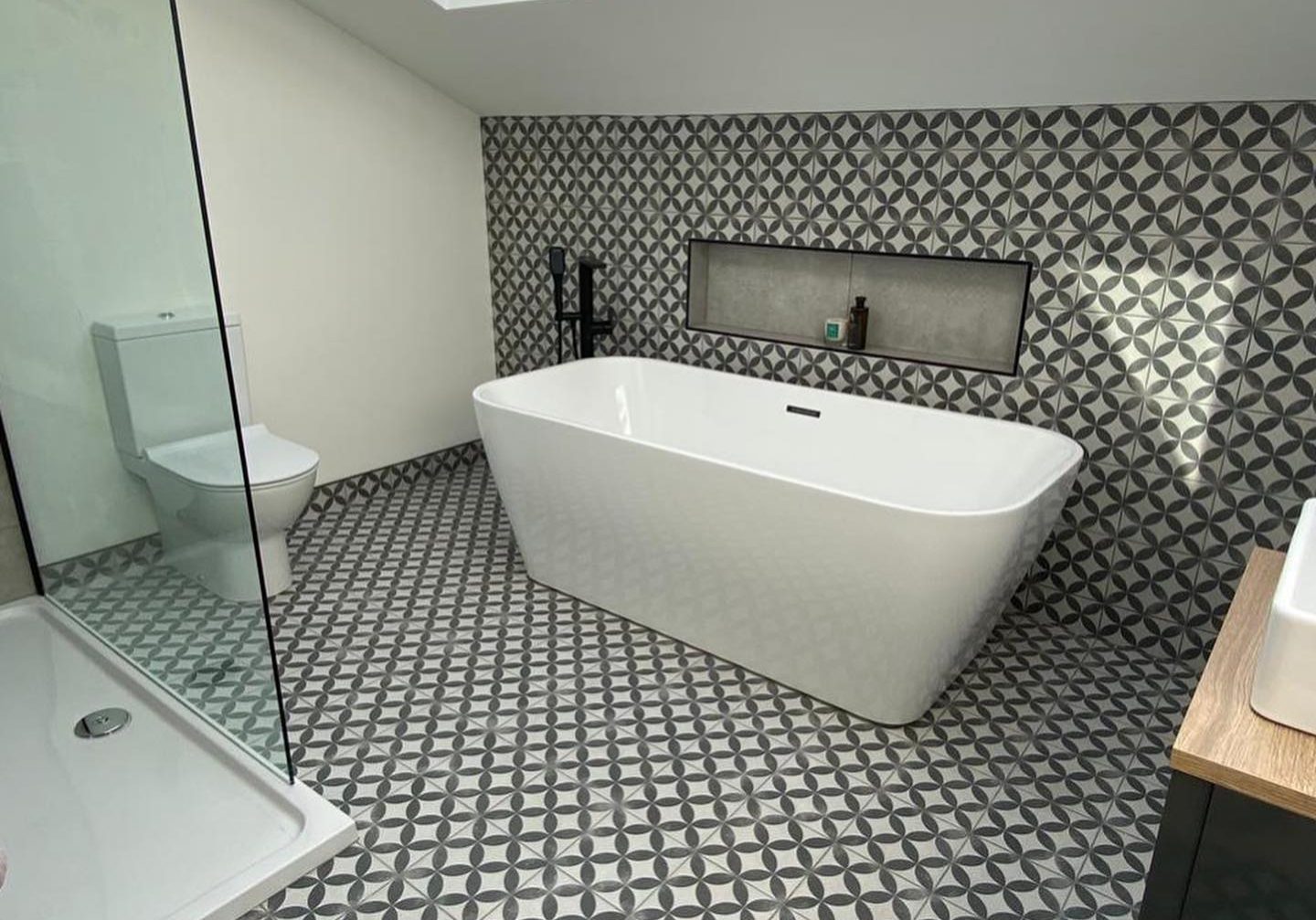 Black and white tiled bathroom with separate bath