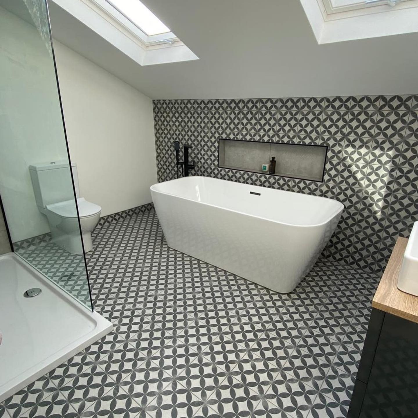 Black and white tiled bathroom with separate bath