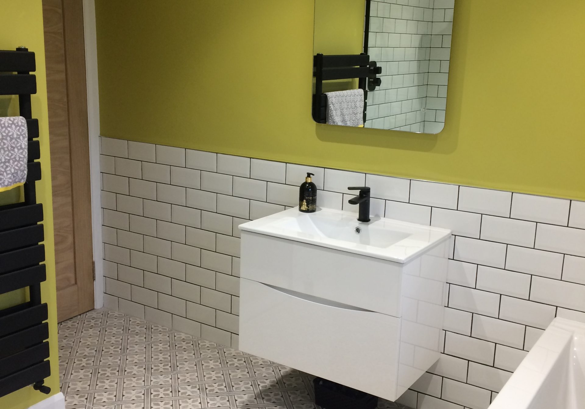 Yellow bathroom wall with white tiles